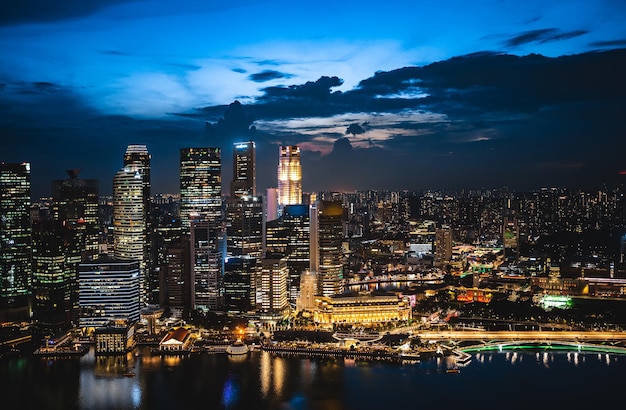 El horizonte de la ciudad de Singapur con un moderno edificio de arquitectura de rascacielos para el concepto de negocios financieros y viajes en el paisaje urbano de Asia, un hito urbano, la bahía del puerto deportivo en el cielo del atardecer del distrito nocturno