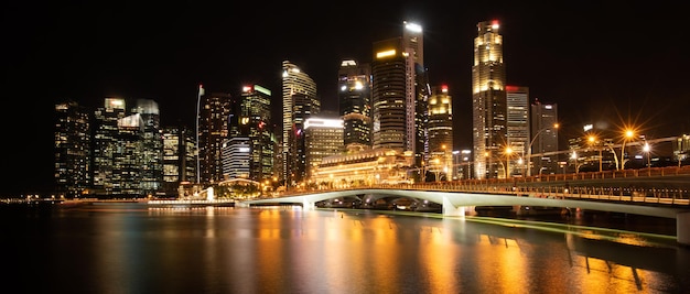 El horizonte de la ciudad de Singapur con un moderno edificio de arquitectura de rascacielos para el concepto de negocios financieros y viajes en el paisaje urbano de Asia, un hito urbano, la bahía del puerto deportivo en el cielo del atardecer del distrito nocturno