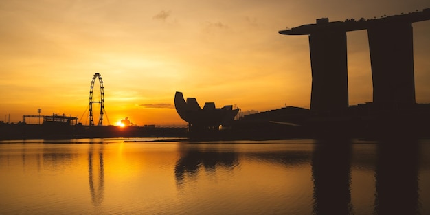 El horizonte de la ciudad de Singapur con un moderno edificio de arquitectura de rascacielos para el concepto de negocios financieros y viajes en el paisaje urbano de Asia, un hito urbano, la bahía del puerto deportivo en el cielo del atardecer del distrito nocturno