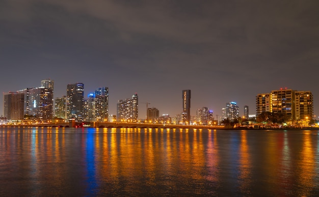 Horizonte da paisagem urbana de Miami, Flórida, na Baía de Biscayne. Panorama ao entardecer com arranha-céus urbanos e ponte sobre o mar com reflexão.