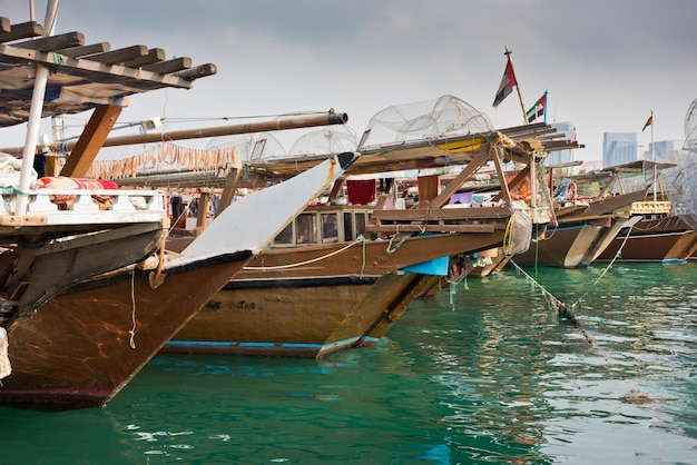 Horizonte de edifícios de Abu Dhabi com velhos barcos de pesca