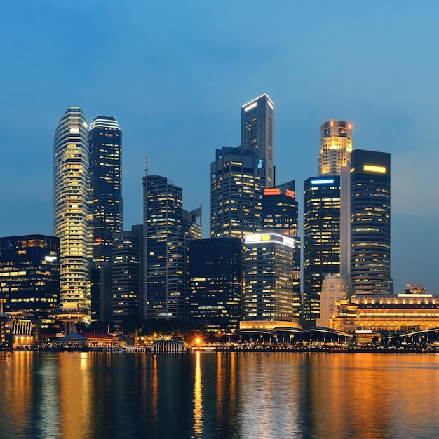 Horizonte de singapura à noite com edifícios urbanos