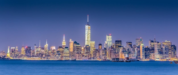 Foto horizonte do centro de new york city manhattan ao entardecer com arranha-céus iluminados sobre o panorama do rio hudson. composição horizontal, copie o espaço.