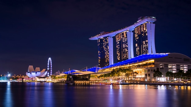 Horizonte del edificio del negocio de Singapur en la madrugada con la reflexión en waterbay en el tiempo crepuscular. Marina iluminada arena de la bahía por la noche