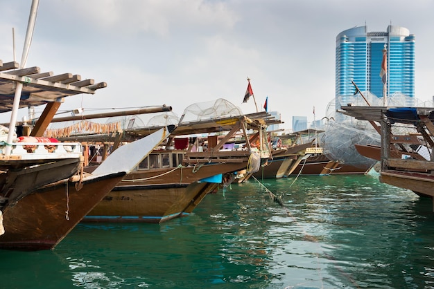 Horizonte de edificios de Abu Dhabi con viejos barcos de pesca en el frente