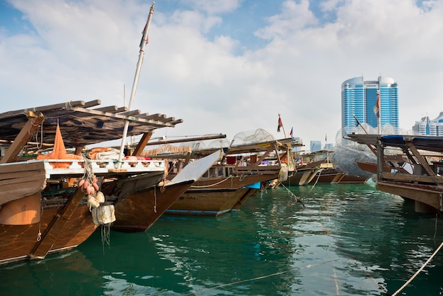 Horizonte de edificios de Abu Dhabi con viejos barcos de pesca