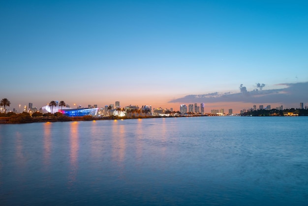 Horizonte del paisaje urbano de Miami, Florida en la Bahía de Biscayne. Panorama al atardecer con rascacielos urbanos y puente sobre el mar con reflejo.