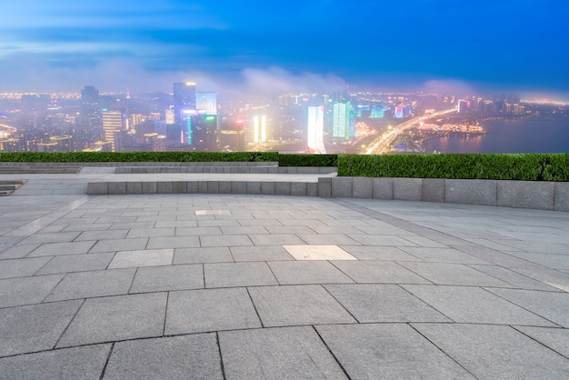 Horizonte panorámico y baldosas cuadradas vacías con edificios modernos