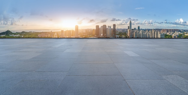 Horizonte panorámico y baldosas cuadradas vacías con edificios modernos