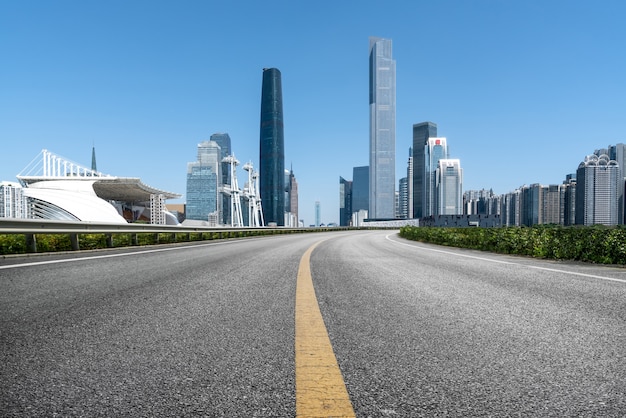 Horizonte panorámico y carretera asfaltada vacía con edificios modernos