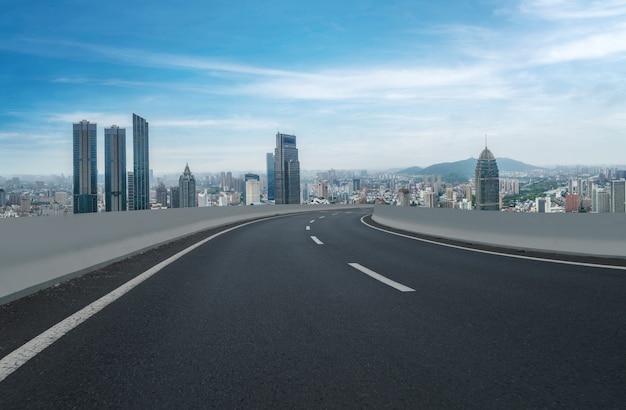 Horizonte panorámico y carretera asfaltada vacía con edificios modernos