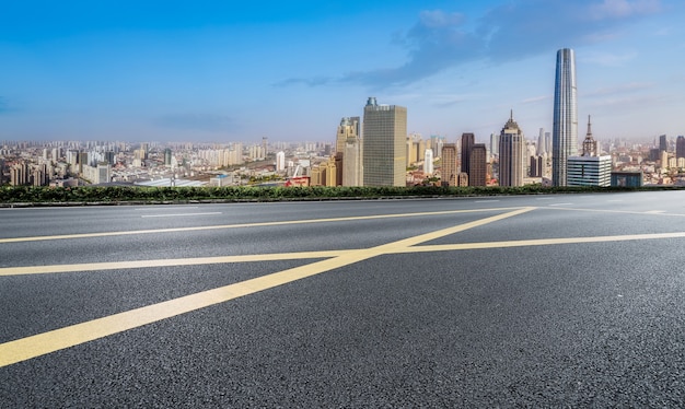 Horizonte panorámico y carretera asfaltada vacía con edificios modernos