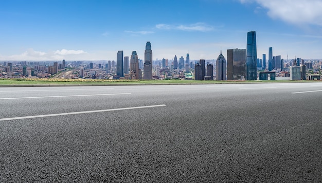 Horizonte panorámico y carretera asfaltada vacía con edificios modernos