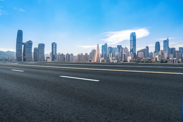 Horizonte panorámico y carretera asfaltada vacía con edificios modernos