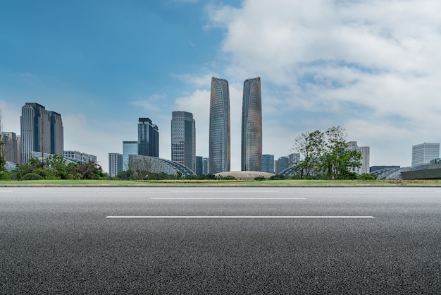 Horizonte panorámico y carretera asfaltada vacía con edificios modernos