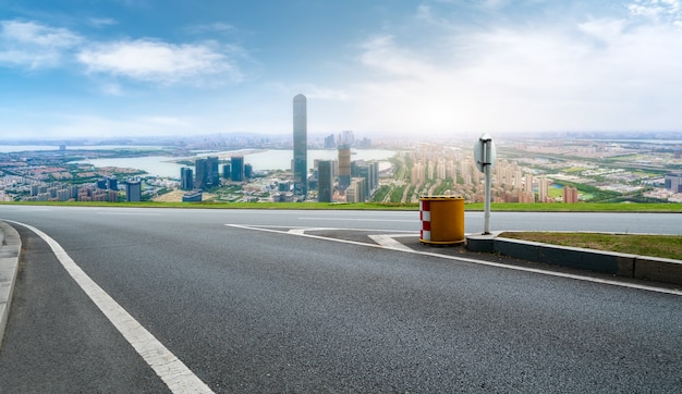 Horizonte panorámico y carretera asfaltada vacía con edificios modernos