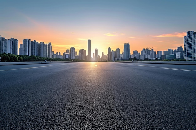 Horizonte panorámico de la ciudad y edificios con carretera asfaltada vacía al amanecer.