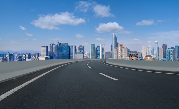 Horizonte panorâmico e estrada de asfalto vazia com edifícios modernos