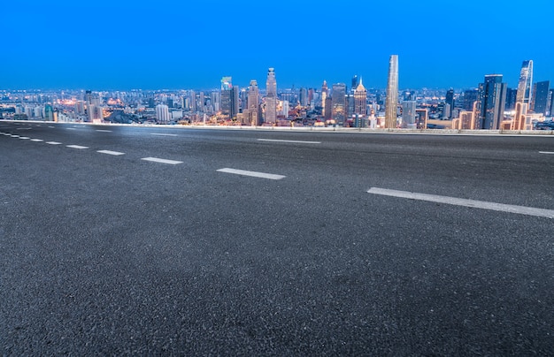 Horizonte panorâmico e estrada de asfalto vazia com edifícios modernos