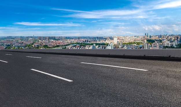 Horizonte panorâmico e estrada de asfalto vazia com edifícios modernos