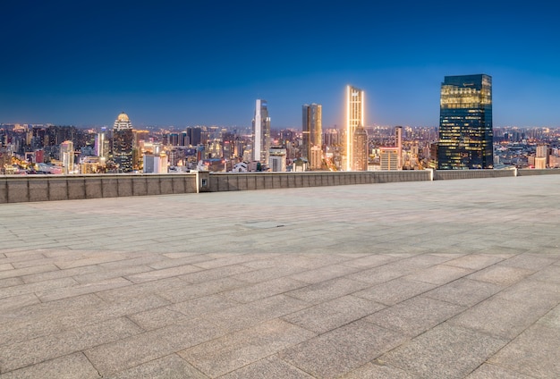 Foto horizonte panorâmico e ladrilhos quadrados vazios com edifícios modernos