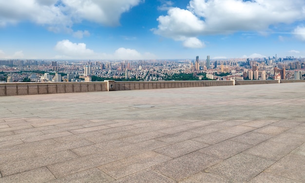 Horizonte panorâmico e ladrilhos quadrados vazios com edifícios modernos