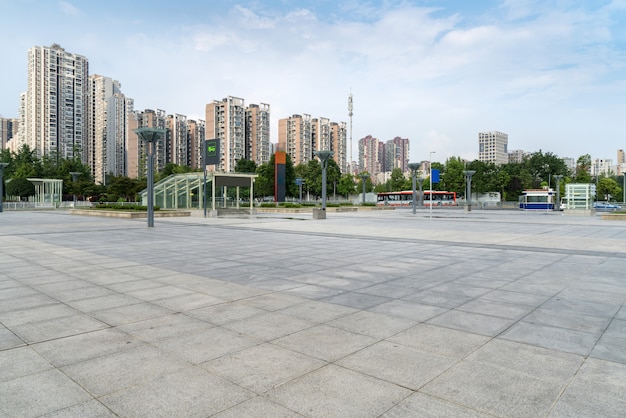 Horizonte panorámico y edificios con piso cuadrado de hormigón vacío