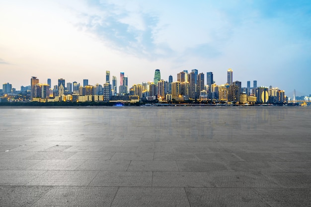 Horizonte panorámico y edificios con piso cuadrado de hormigón vacío