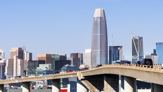 Horizonte urbano en el centro de San Francisco en un día soleado con vehículos de cielo azul claro conduciendo en una autopista elevada en primer plano