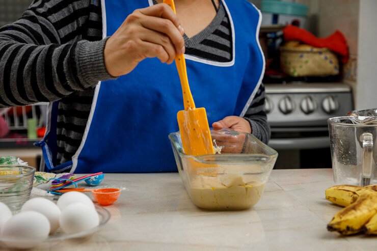 Foto hornear en casa mujer preparando un panqueque de plátano en su cocina