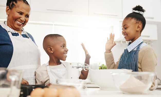Hornear cinco o éxito con la familia negra en la cocina de la casa cocinando pastelería comida juntos amor sonrisa o apoyo con la abuela hermano y hermana en el apartamento aprendiendo a hornear postre