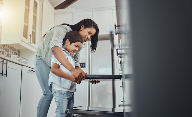 Foto hornear divertido y niño ayudando a la madre con la comida cocinar y aprender junto al horno en la cocina desayuno feliz y madre y niño haciendo la cena de almuerzo o un bocadillo juntos en su casa familiar