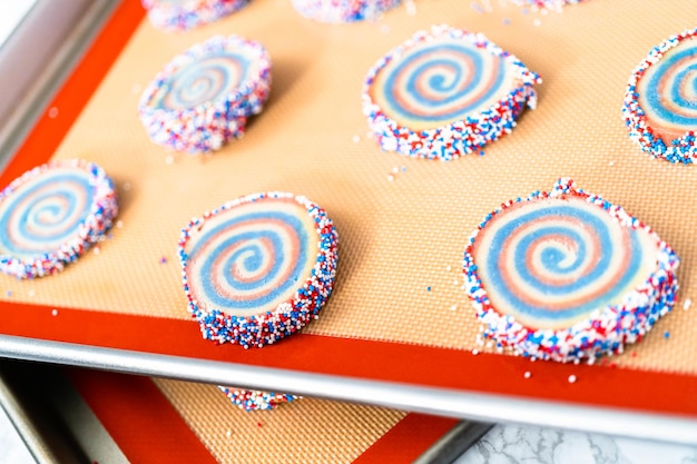 Hornear galletas de azúcar de molinete rojas, blancas y azules para la celebración del 4 de julio.