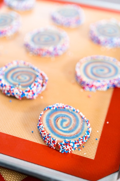 Hornear galletas de azúcar de molinete rojas, blancas y azules para la celebración del 4 de julio.