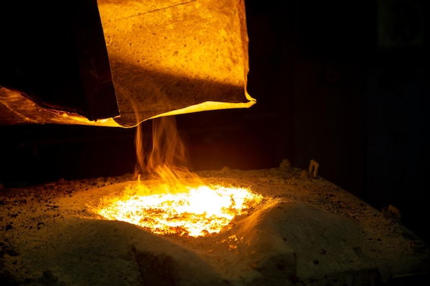 Foto horno metalúrgico con campana extractora y fundición de metal con escoria y vapor