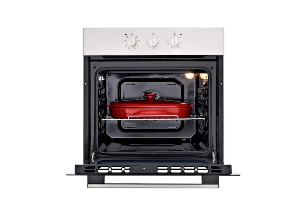 Horno negro con panel de control plateado, tres perillas de control redondas Puerta abierta con un plato para hornear rojo dentro de las luces en la vista frontal Aislar en blanco