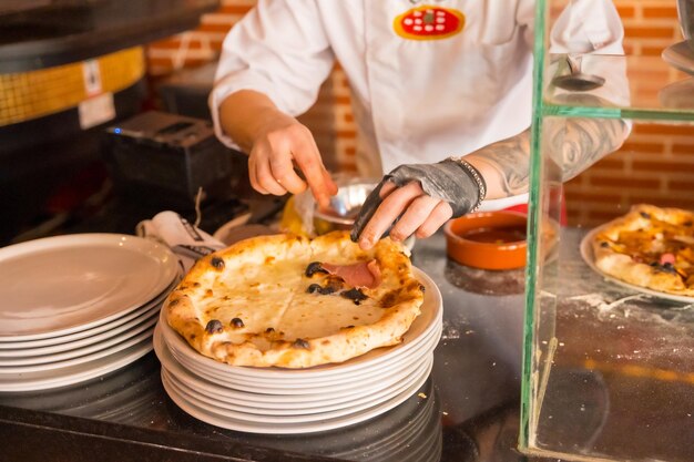 Horno de pizza artesanal Chef preparando la pizza para venderla caliente y lista para los clientes