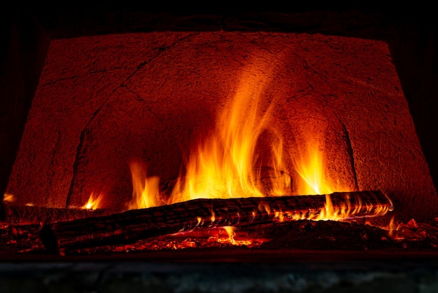 Horno de pizza de ladrillo refractario para soportar altas temperaturas con quema de leña y estando preparado para hornear pizzas.