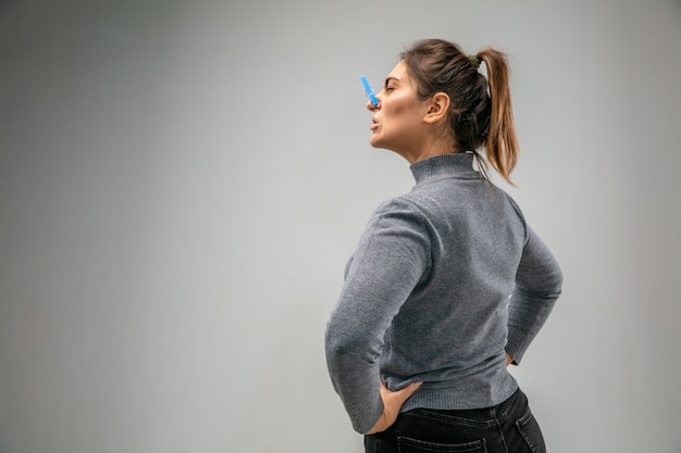 Foto horrível. mulher caucasiana com fecho de pino de proteção respiratória contra a poluição do ar e partículas de poeira excedem os limites de segurança. conceito de saúde, meio ambiente e ecologia. alergia, dor de cabeça.