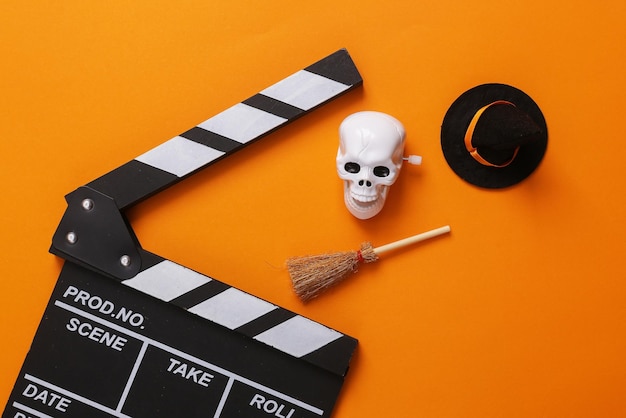 Horrorfilm Halloween-Konzept Film-Clapperboard mit Halloween-Dekor auf orangefarbenem Hintergrund