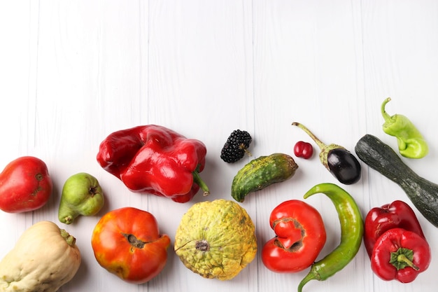 Hortaliças e bagas orgânicas feias pepino pimentão doce e picante berinjela amora dogwood abóbora abobrinha pêra e tomate em fundo branco conceito de comida feia Copiar espaço