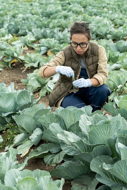 Horticultora séria de óculos e luvas