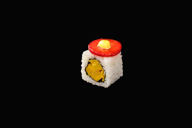 Hosomaki-Rolle mit japanischem Omelett, japanischer Mayonnaise, Erdbeeren, Unagi-Sauce, Reis isoliert auf schwarzem Hintergrund