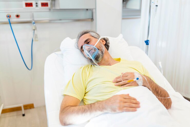 En el hospital, un paciente mayor de covid-19 descansa en la cama con una máscara de oxígeno Un hombre en recuperación duerme en la sala moderna del hospital