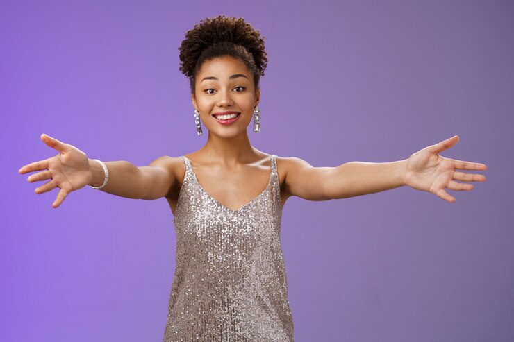 Foto hospitaleiro carinhoso charmoso jovem afro-americano elegante vestido de noite convidando os hóspedes estender os braços abraço abraço abraçar amigos sorrindo tocado encantado gesto de boas-vindas fundo azul.