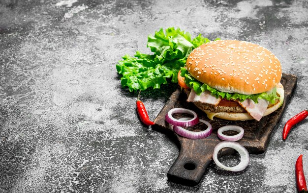 Hot Burger mit Rindfleisch, Gemüse und Chilischoten. Auf einem rustikalen Hintergrund.