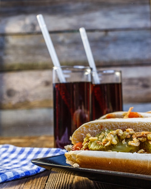 Hot Dog americano con ingredientes y refrescos