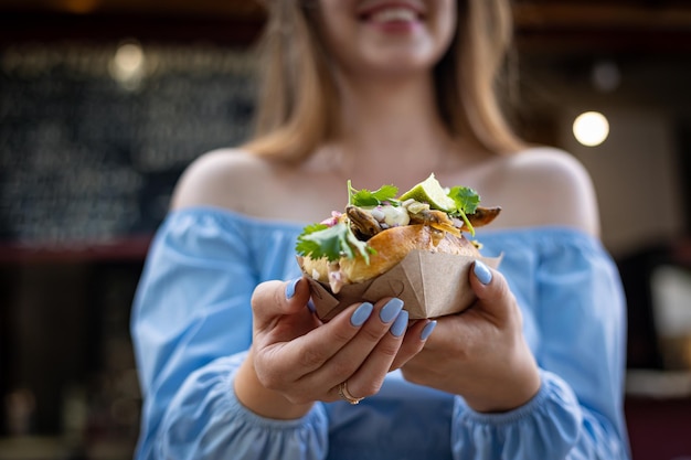 Hot Dog aus Fisch und Gemüse, mit Zitrone und Gemüse. In einer Einwegschale. Straßenessen