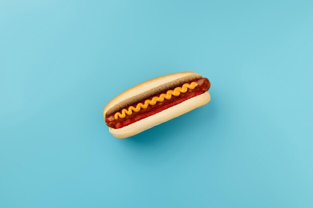 Foto hot dog clásico con salsa de tomate y mostaza en el menú de fondo azul para restaurante