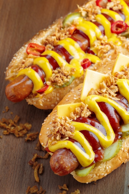 Hot Dog mit gelbem Senf und Ketchup auf Holzbrett